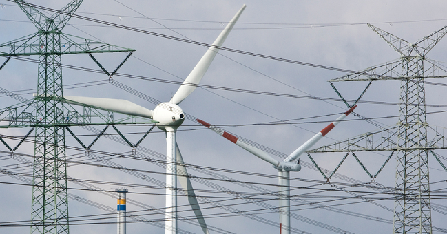 Windräder vor Strommasten