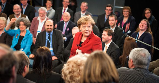 Chancellor Angela Merkel surrounded by interested ciitzens during the discussion
